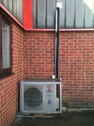 server room outdoor air conditioning unit installed outside of building with basic cage system